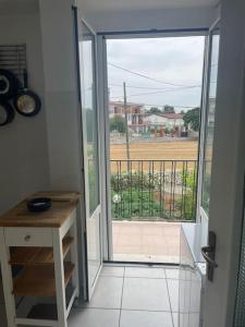 Une porte ouverte s'ouvre sur un balcon offrant une vue sur un champ. dans l'établissement Casa vacanze da Tonino, à Noci