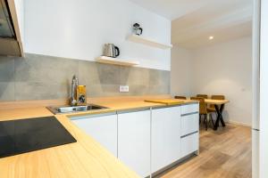 een keuken met witte kasten en een eettafel bij Bright Modern - 2Bedrooms 1Bathroom - Delicias in Madrid