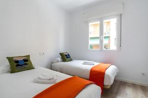 2 bedden in een witte kamer met een raam bij Bright Modern - 2Bedrooms 1Bathroom - Delicias in Madrid