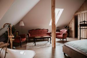 a bedroom with red furniture and a bed and a tub at Apartament z wanną wolnostojącą in Stare Miasto