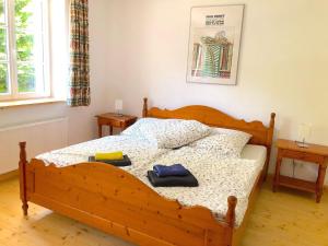 1 dormitorio con 1 cama de madera y 2 toallas en The coach house en Altenherfen