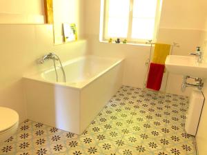 y baño con bañera, aseo y lavamanos. en The coach house en Altenherfen