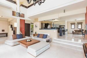 sala de estar de planta abierta con muebles blancos y cocina en Halide Luxury Villa, en Ixia