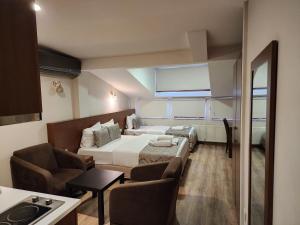 Wide Suites Taksim في إسطنبول: غرفه فندقيه بسرير واريكه