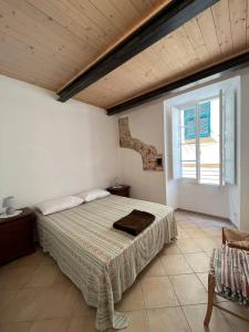 een slaapkamer met een bed en een groot raam bij Appartamento vacanze mare Loano in Loano