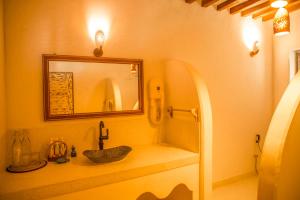 a bathroom with a sink and a mirror at Kijani Hotel in Lamu