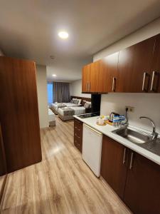 a kitchen with wooden cabinets and a living room at Wide Suites Taksim in Istanbul