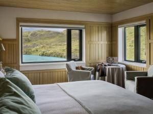a bedroom with a bed and a large window at Explora en Torres del Paine - All Inclusive in Torres del Paine