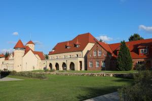 una casa grande con un césped verde delante de ella en Der Westflügel Ritter Florin, en Stolpe auf Usedom