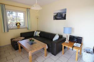 ein Wohnzimmer mit einem schwarzen Sofa und einem Tisch in der Unterkunft Seerose in Bliesdorf