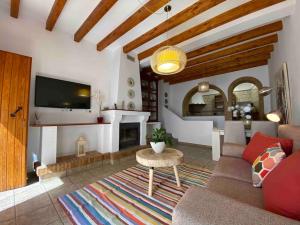 a living room with a couch and a table and a tv at La Casa del San Antón in Níjar