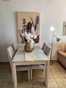 a dining room table with a vase of flowers on it at La Casa del San Antón in Níjar