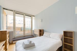 a bedroom with a bed and a large window at Pass the Keys Stunning balcony apartment - Central East London in London