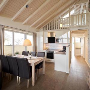 a kitchen and dining room with a table and chairs at Luxuswellnesshaus Strandhus in Bliesdorf