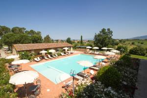 una grande piscina con ombrelloni e sedie di Agriturismo S.Angelo a Foiano della Chiana