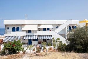 a white house with blue doors and windows at Hara's Studio in Perdika