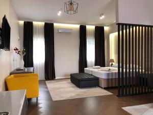a bedroom with a king sized bed and a yellow chair at Luxury Villa with Private Pool and Jacuzzi in Gnojnice