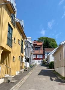 an empty street in a town with yellow buildings at Sjarmerende Town House i sentrum in Tønsberg