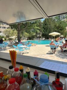 - une vue sur la piscine depuis une table avec des bouteilles dans l'établissement Hotel Monte Mare - all inclusive, à Čanj