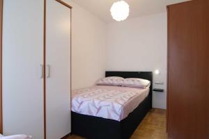 Dormitorio pequeño con cama y armario en Apartman Nane, en Kaštela