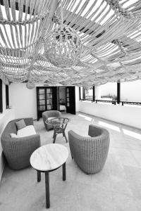 a living room with couches and tables and a chandelier at Kalidon beach Hotel in Kokkari