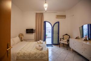a bedroom with a bed and a chair and a window at Hara's Studio in Perdika
