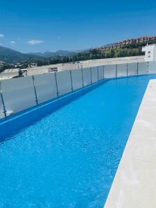 una piscina en la parte superior de un edificio con agua azul en Happy holidays en Marbella