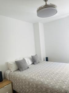 Habitación blanca con cama con almohadas en Happy holidays en Marbella