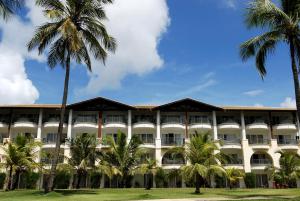 a large building with palm trees and palm trees at Sauipe Resorts - All Inclusive in Costa do Sauipe