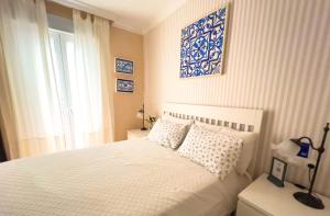 a bedroom with a white bed and a window at Como en casa in Málaga