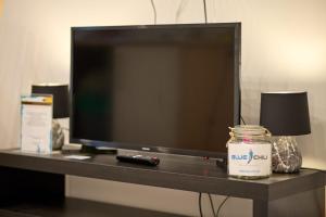 TV de pantalla plana sentada en una mesa con una vela en Blue Chili Apartments Prenzlauer Berg en Berlín