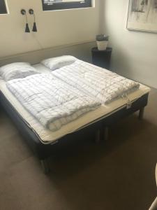 a large bed in a bedroom with a mattressvisor at Family rooms in the center in Grindsted