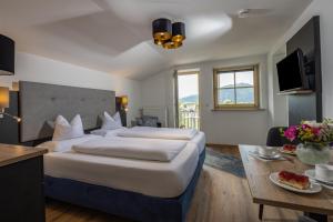 ein Hotelzimmer mit 2 Betten und einem Tisch in der Unterkunft Hubertus Appartements Inzell in Inzell