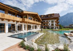 a hotel with a swimming pool in front of a building at NOVA Moments Boutique Hotel in Pertisau
