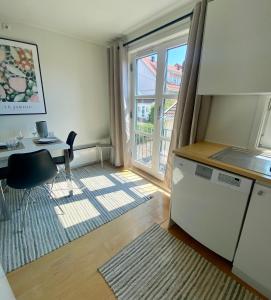 a kitchen with a desk and a table and a window at Sjarmerende Town House i sentrum in Tønsberg