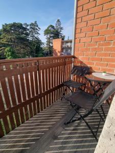 a table and a chair sitting on a patio at Apartment Kurši in Kolka