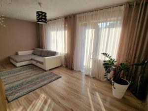a living room with a couch and a large window at Apartment Kurši in Kolka