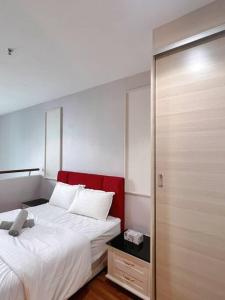 una camera con un letto bianco e una testiera rossa di Cozy Staycation @ ICITY near SOGO & Central I-City a Shah Alam