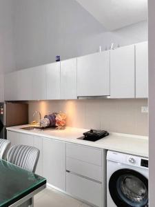 una cucina con armadietti bianchi e lavatrice di Cozy Staycation @ ICITY near SOGO & Central I-City a Shah Alam