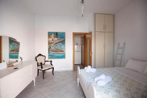 a bedroom with a bed and a desk and a chair at Hara's Studio in Perdika