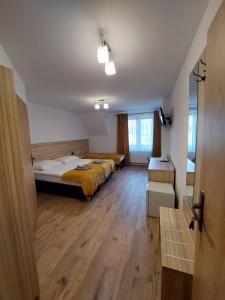 1 dormitorio con 1 cama y suelo de madera en Dziadkowiec en Białka Tatrzanska