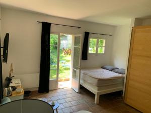 - une chambre avec un lit et une porte coulissante en verre dans l'établissement le calme chambre 2, à Saint-Tropez