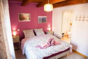 1 dormitorio con 1 cama con pared de color rosa en Gîte „La maison des épices“, en Kintzheim