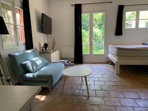 uma sala de estar com um sofá e uma mesa em le calme chambre 2 em Saint-Tropez
