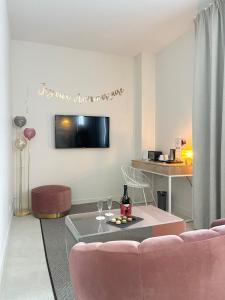 - un salon avec un canapé rose et une table dans l'établissement Brit Hotel Ker Lann Aeroport, à Bruz