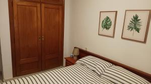 1 dormitorio con 1 cama y armario de madera en El Olivar en La Adrada