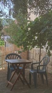 una mesa de picnic y dos sillas bajo un árbol en El Olivar en La Adrada