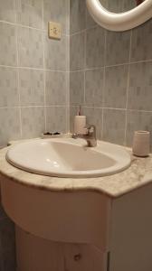 lavabo blanco en el baño con espejo en El Olivar en La Adrada