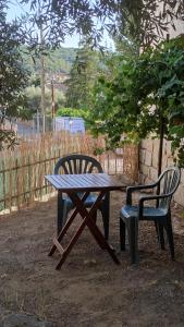 una mesa de picnic y una silla junto a una mesa y un banco en El Olivar en La Adrada