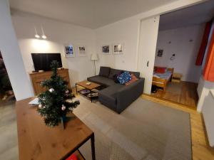 a living room with a couch and a christmas tree at Apartament Roland in Świeradów-Zdrój